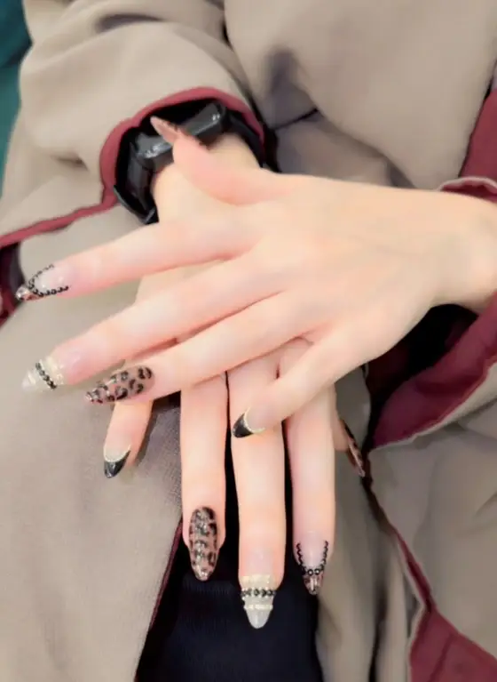 Almond nails with black French tips, leopard print and beads