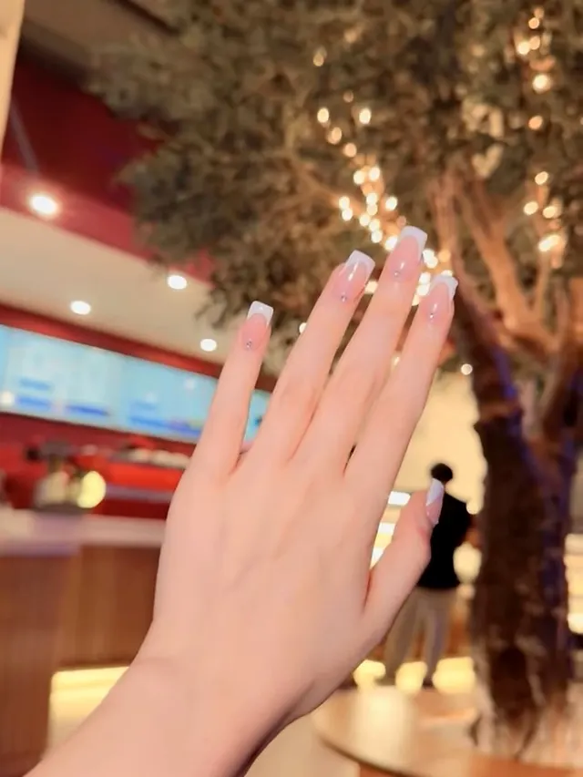 Hand with white French square nails