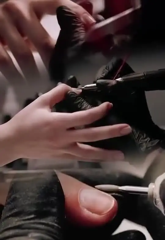Nail technician shaping and polishing nails